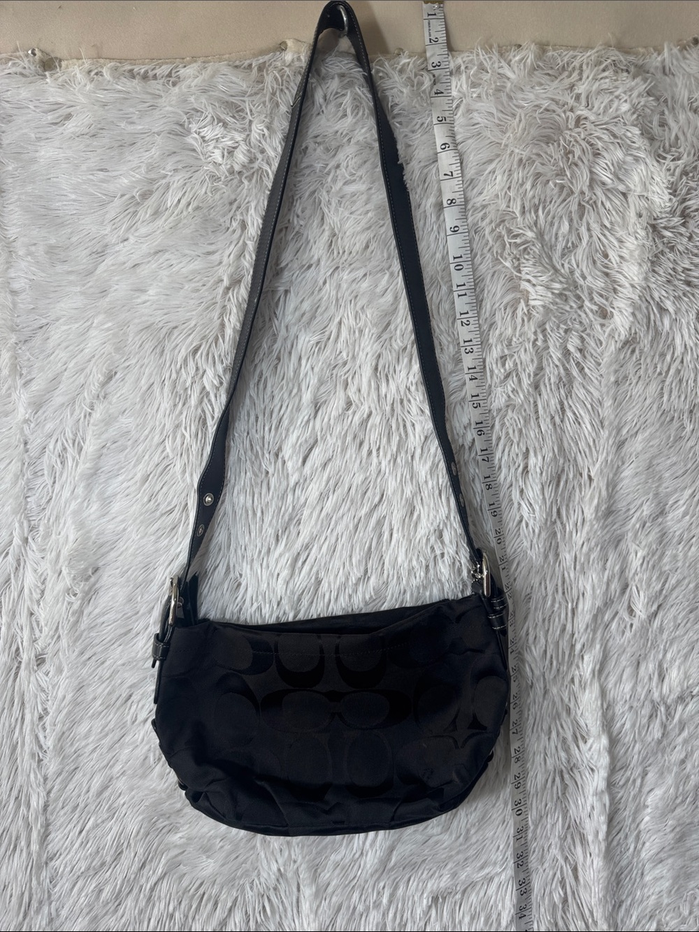 Black Coach crossbody bag with silver hardware and adjustable strap